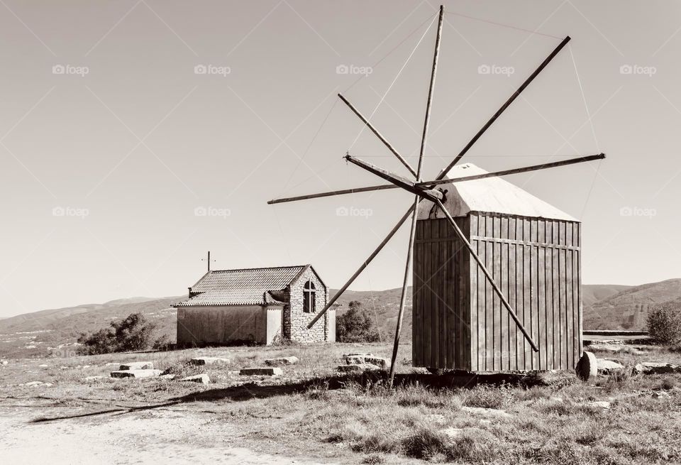 Replica wooden windmill and stone chapel up high on Monte de Vez, Portugal