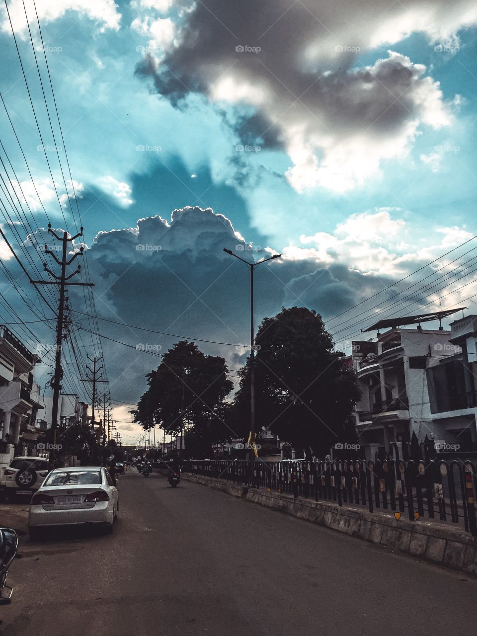 Majestic clouds reflecting through the sun behind, on a street road in India, Lucknow 