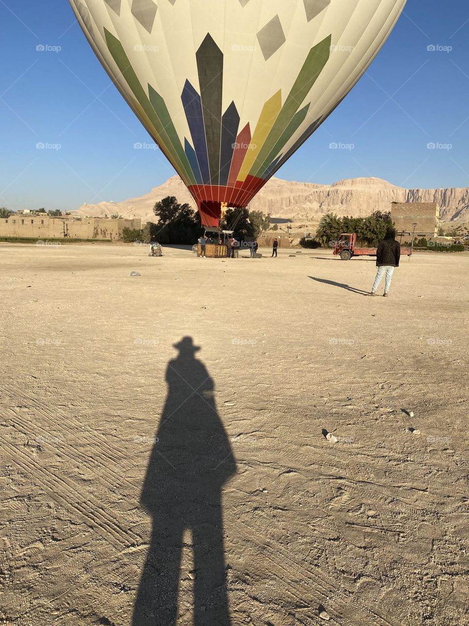 The shadow of a girl who is taking photo for the hot air balloon