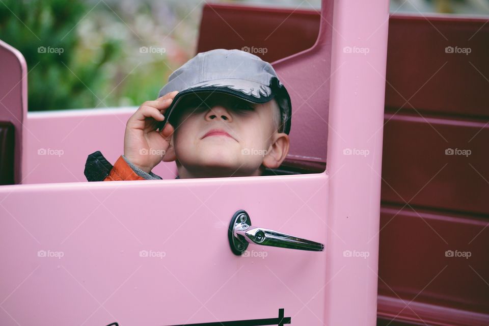 Boy hiding behind his cap