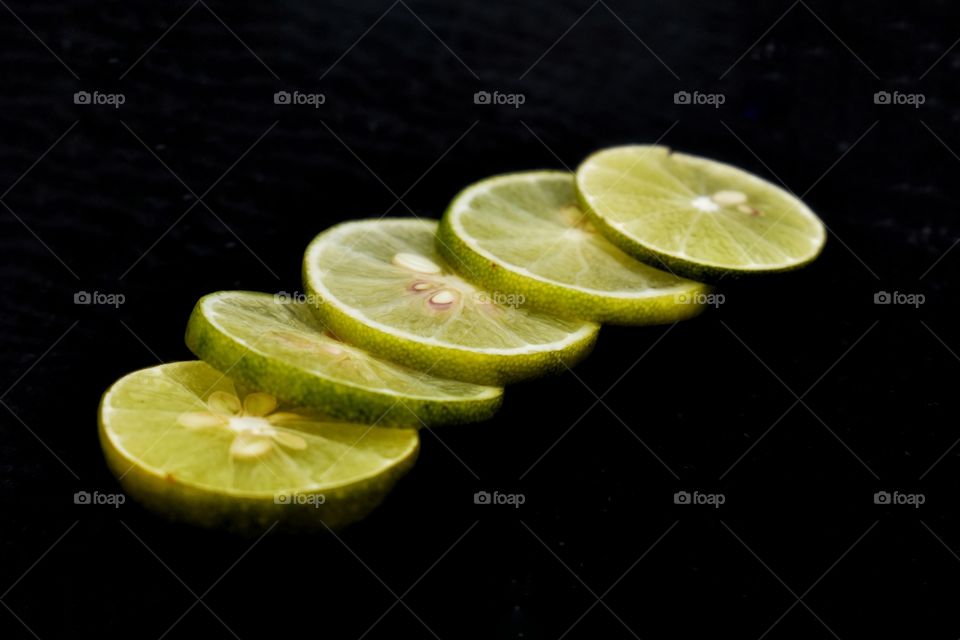 Lemon slices are isolated on a dark background.