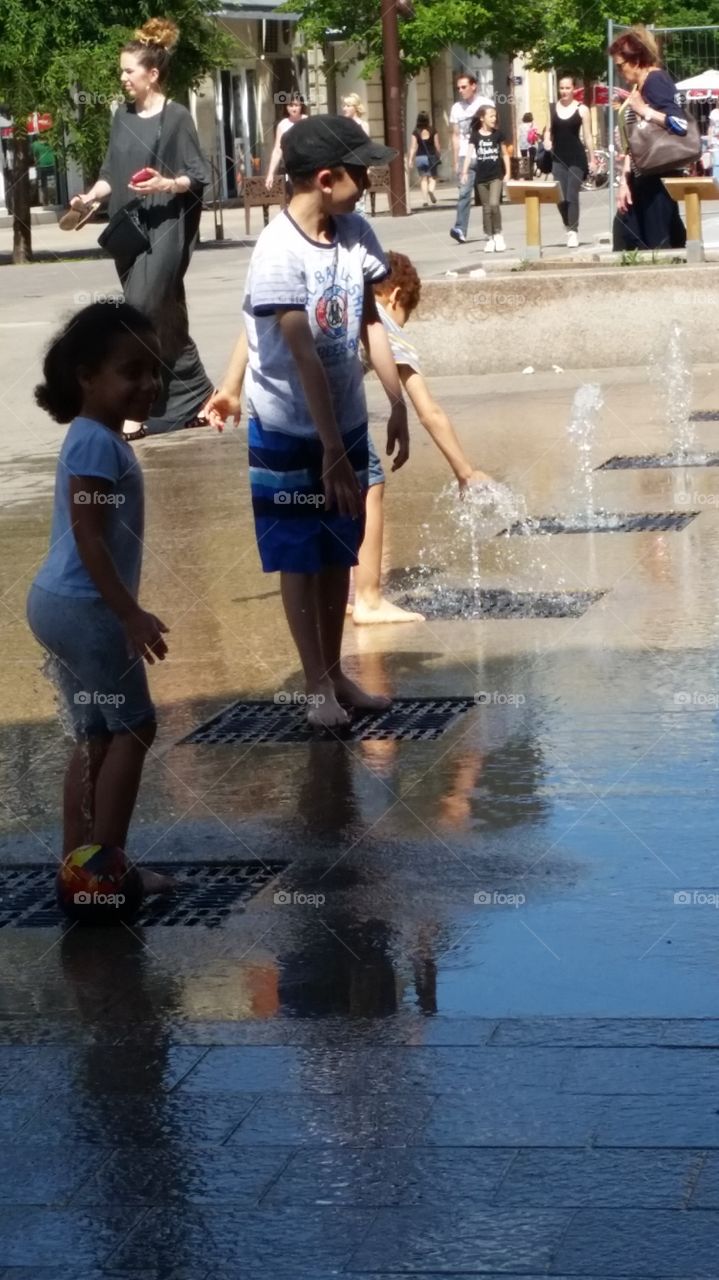 Children enjoying at fountain in the city