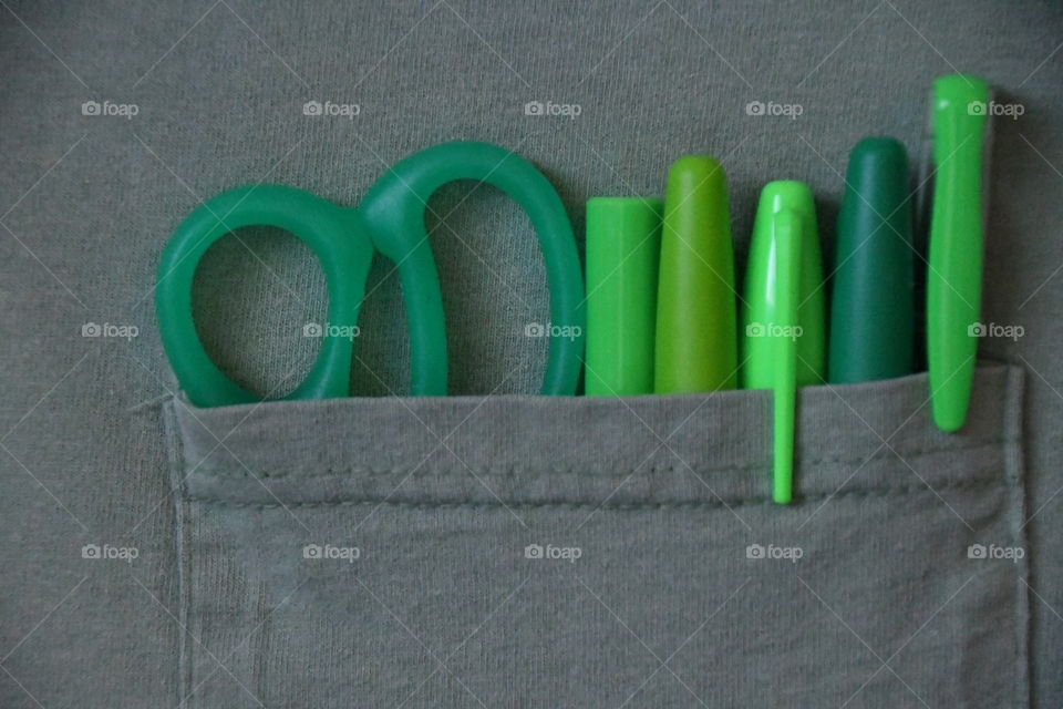 Green pens and scissors in pocket