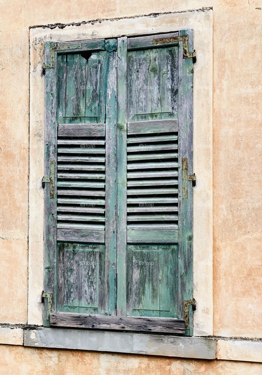 a closed window of an abandoned building lends itself to multiple interpretations