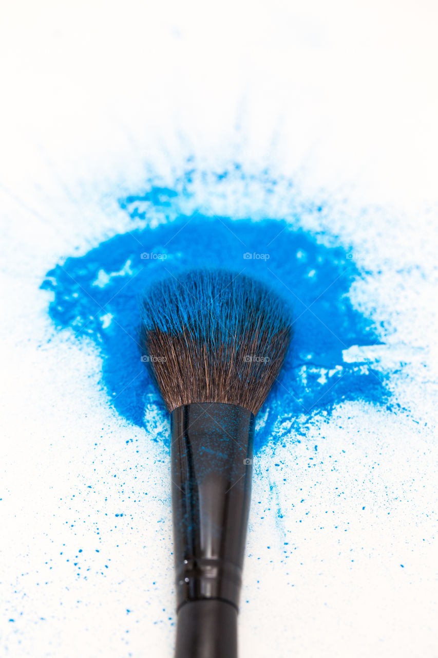 product image of make up brush with blue powder on pure white background