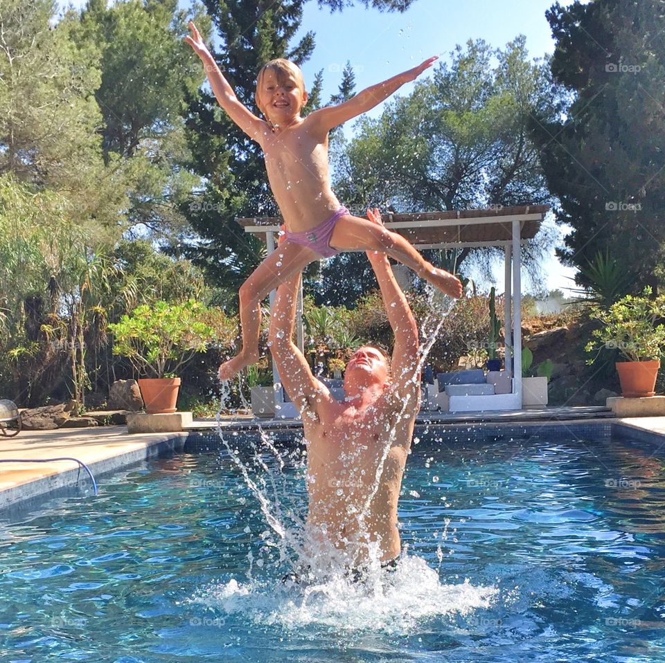 Girl playing with her father in swimming pool
