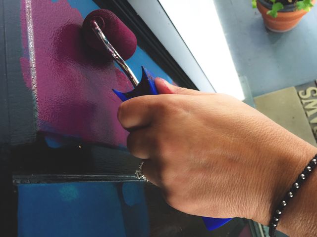 Women paint on door with paint roller