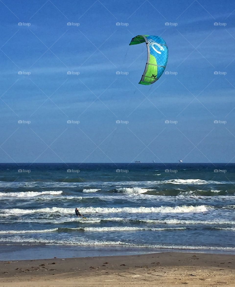 Kite surfer riding the waves at the beach