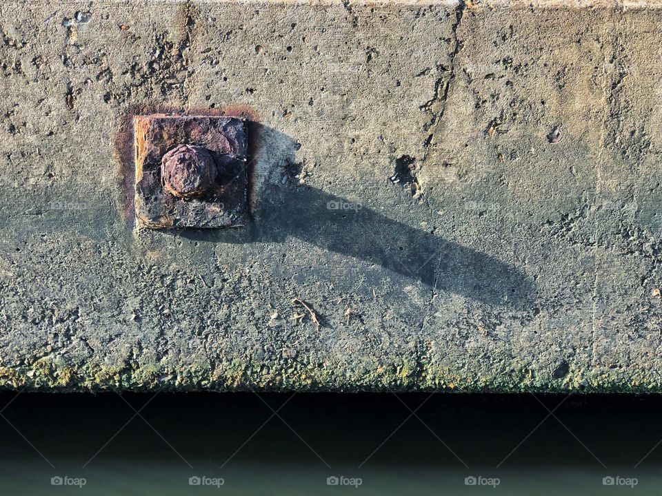 Rusted steel anchor bolt at concrete bulkhead 