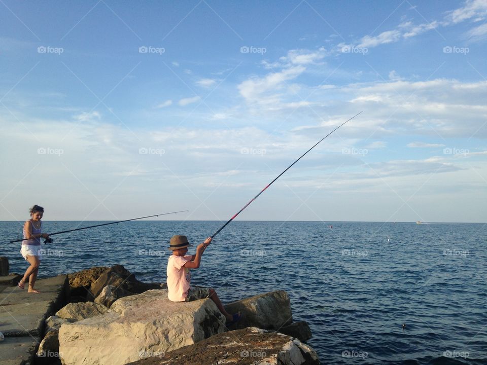 Fishing time. Big sister and little bro were fishing by the sea