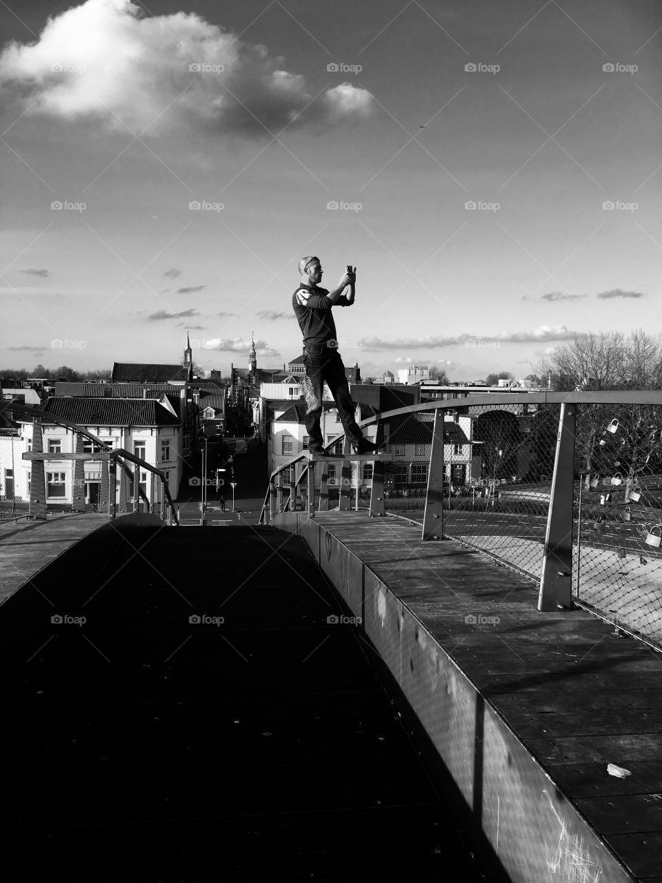 Man standing on bridge photographing
