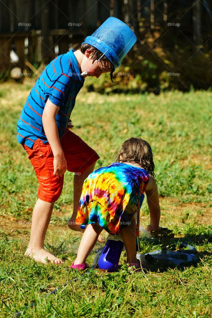 Young Boy And Girl Playing On Grass In Summer