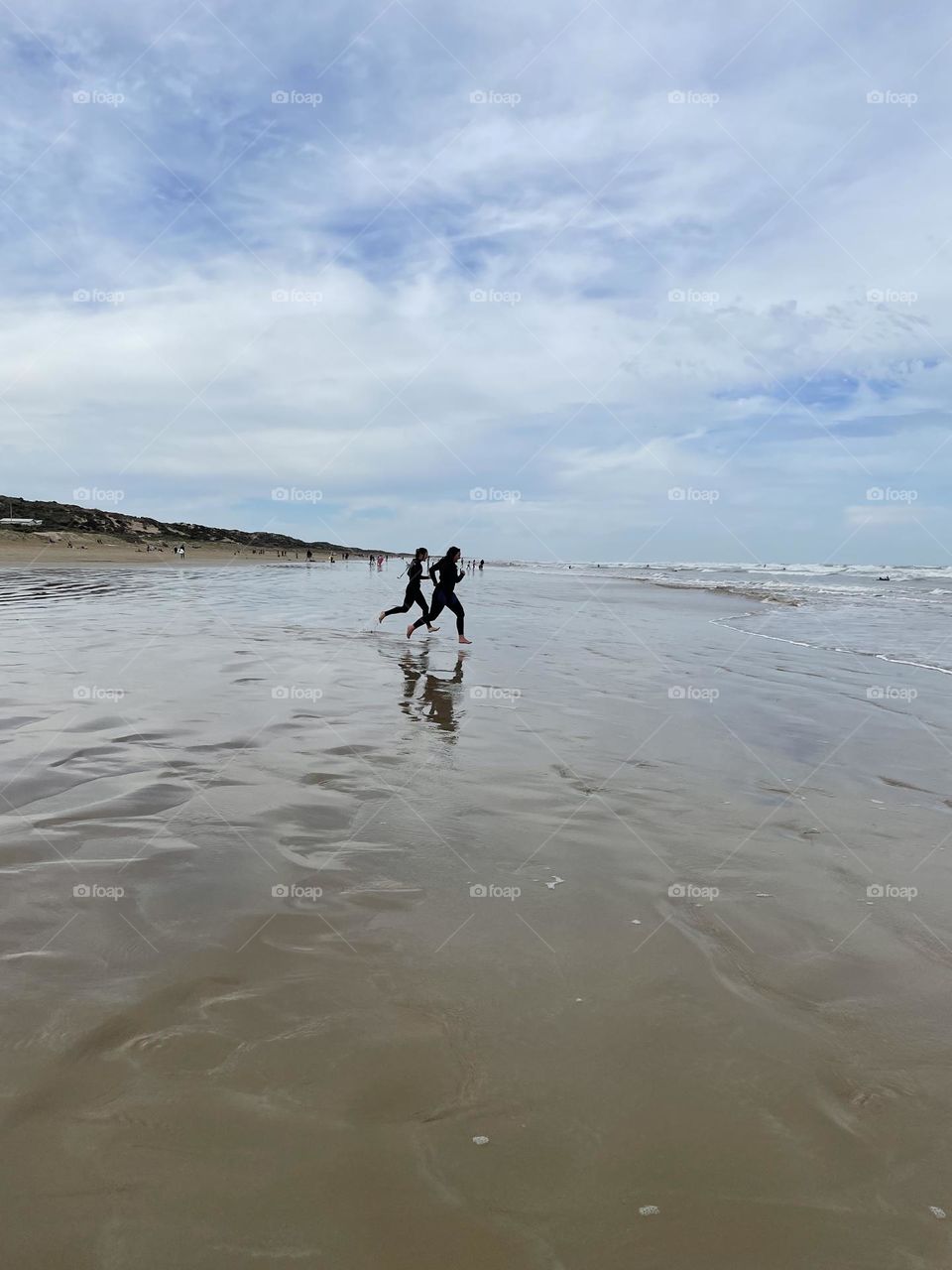 People running to surf on the beach 