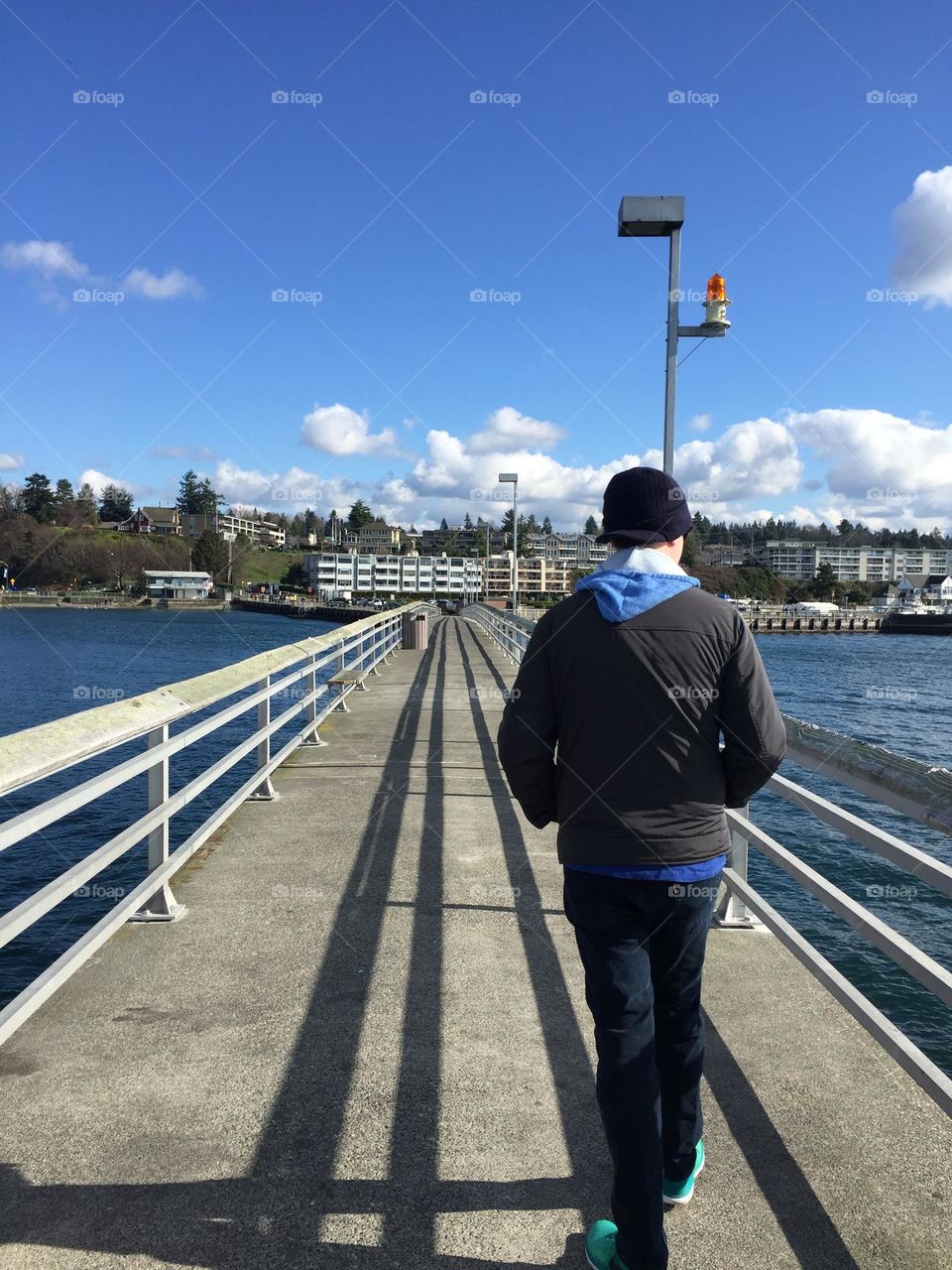 Man walking on a pier on a sunny day
