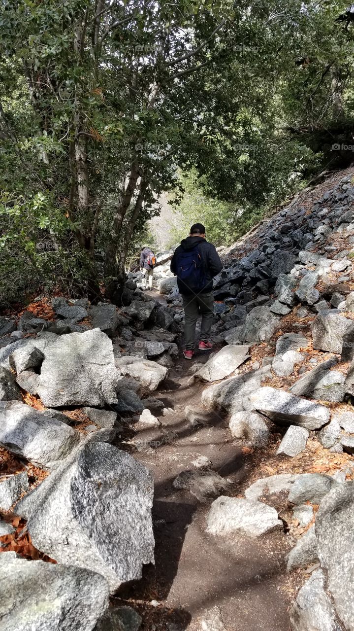 man hiking in a mountain on a rocky trail during spring, summer, winter, fall