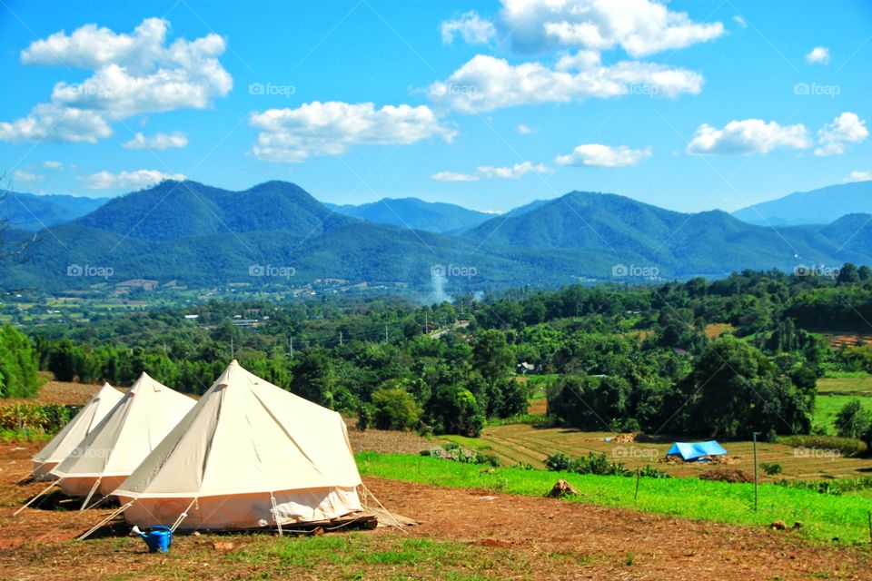 Three white canvas tents are prepared to welcome tourists to relax and stay overnight and enjoy the beautiful natural scenery.