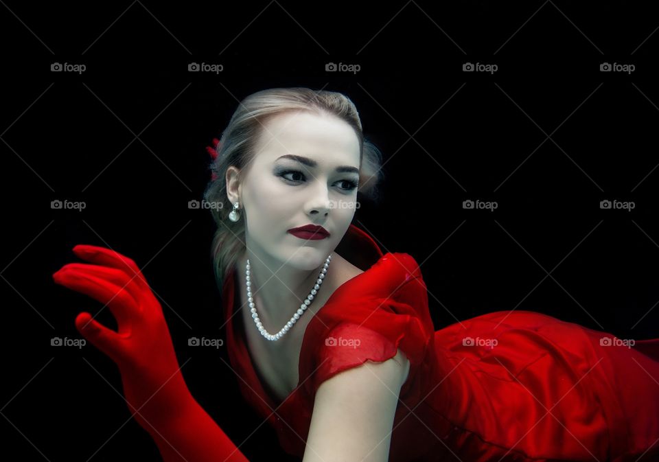 Blonde beauty in Red dress and pearls with long red gloves 