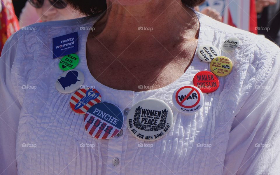 An assortment of old political, human rights, and peace buttons attached to a woman's white blouse during a human rights rally in San Miguel de Allende, Mexico 

