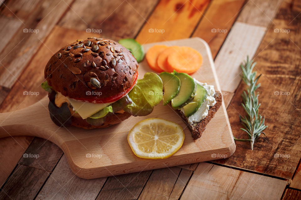 Dark burger with grain bread, cream cheese and avocado