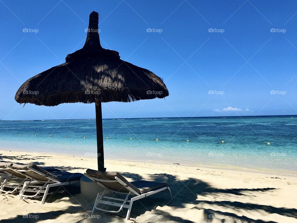 Beautiful relaxing beach view. Blue skies, calm sea and no people in sight. Taken at Sugar Beach, Mauritius