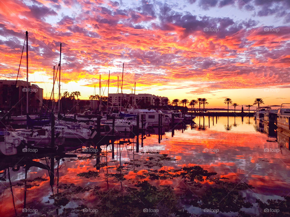 The sky lights up in brilliant hues during a fall sunset over a marina