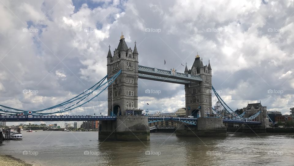 Tower Bridge, London, UK.  The Thames flows under the bridge crowded by tourists.