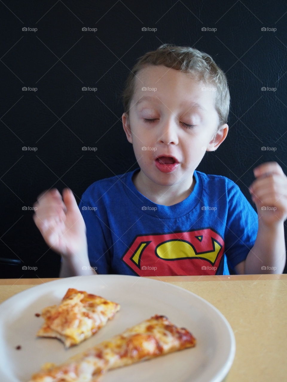 A little boy drops his favorite pizza snack as it is too hot straight from the oven. 