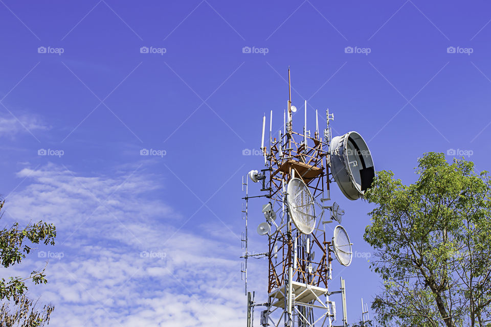 Wave transmission mast, large phone signal with a bright blue sky.