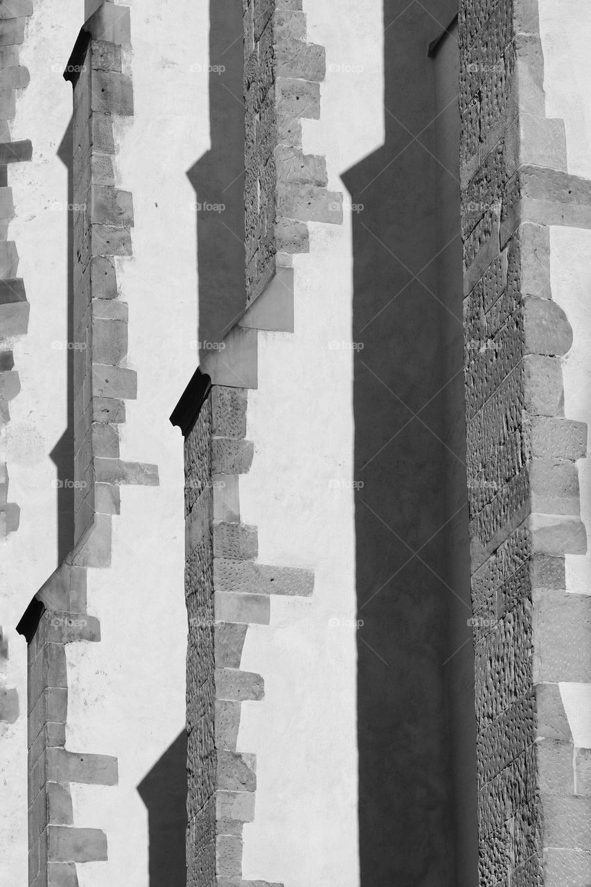 Black and white photo of a church wall in light and shadow