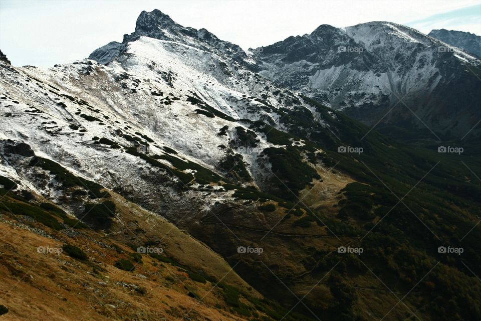 Awesome mountain panorama with trail and snowy hills