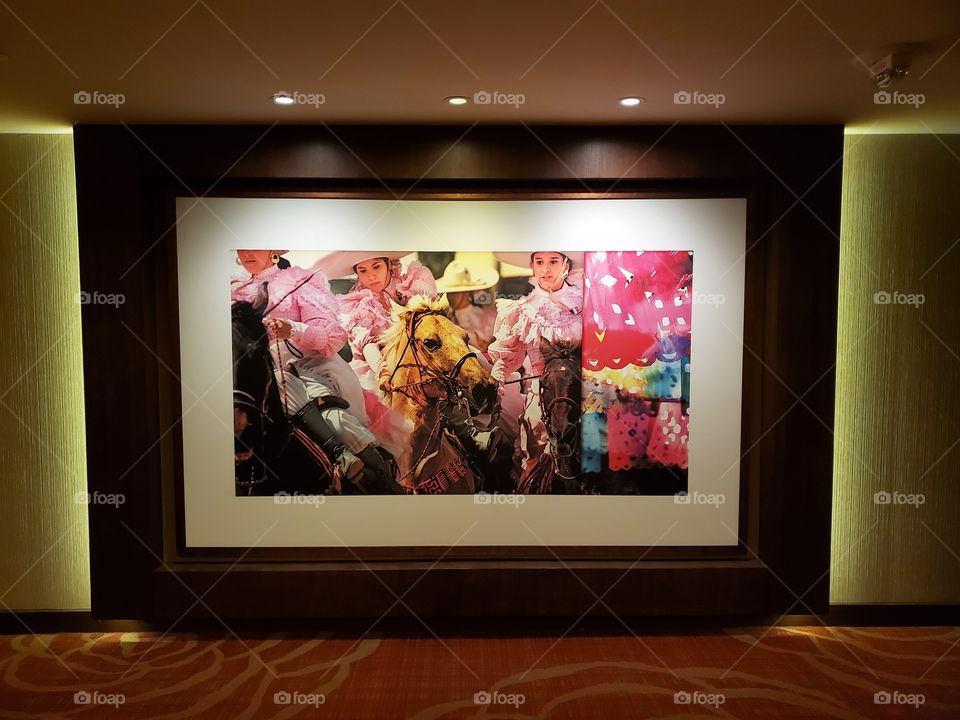 Beautiful large colorful photograph on display at the Hilton Palacio Del Rio of three women riding horses.