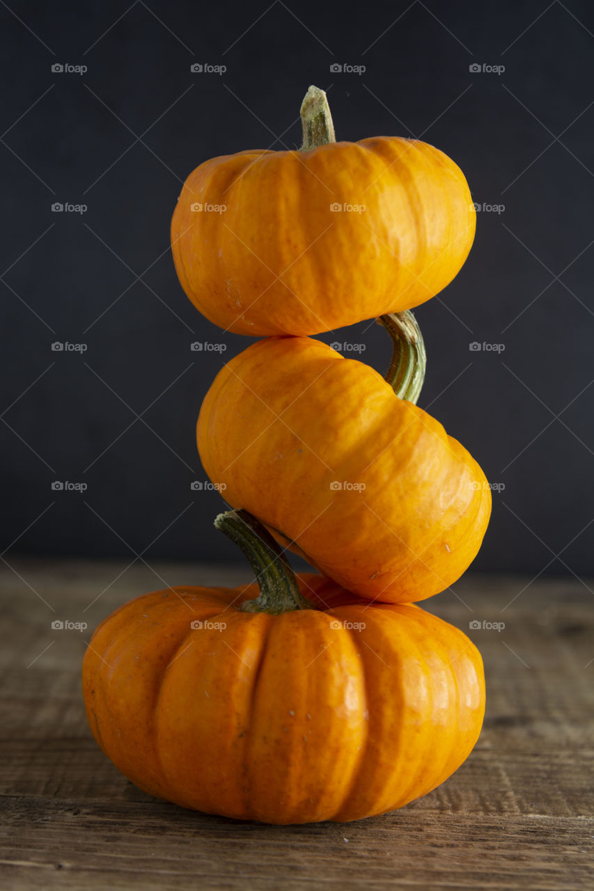 Autumn nackground. Three orange pumpkins, dark background. Fall mood.