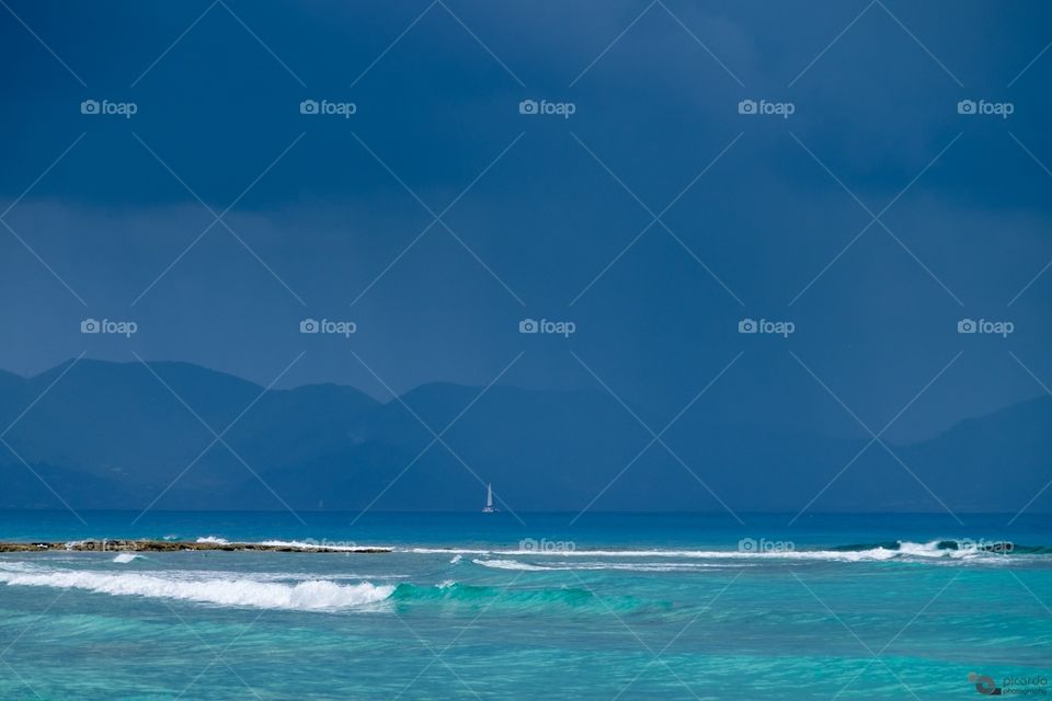 Pouring rain

Small sailboat in the middle of the heavy rain, with the Saint Martin’s landscape on the background, seen from Shaol Bay West beach, Anguilla.