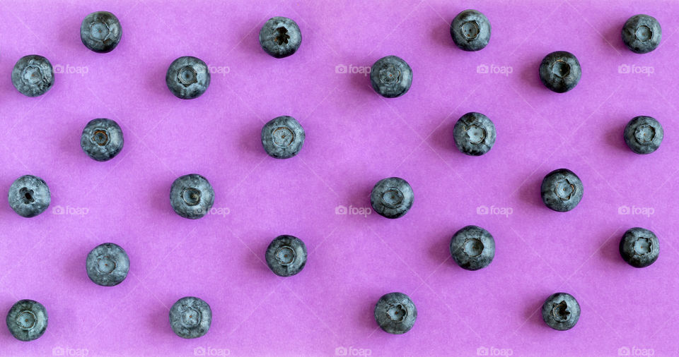 Fresh organic blueberries on purple background. View from above, flatlay