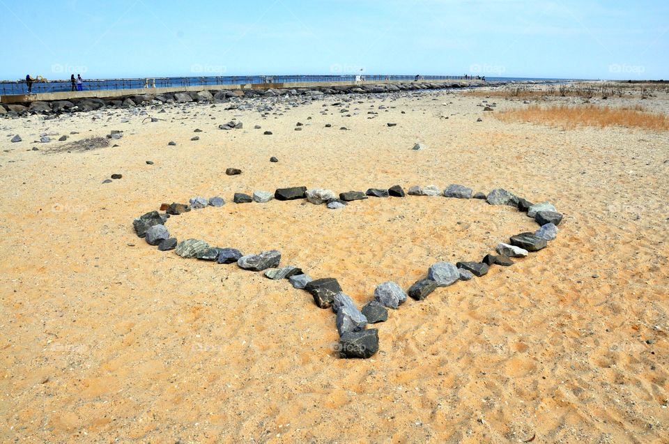 Large rocks form a heart on a Sandy beach