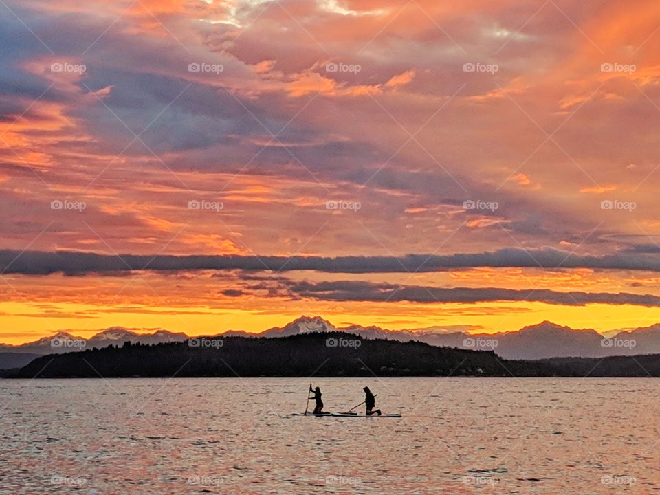 paddle boarding during a bold and golden sunset