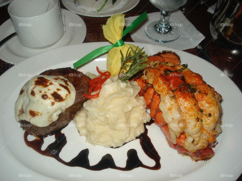 Steak, lobster, mashed potatoes with a lemon bouquet