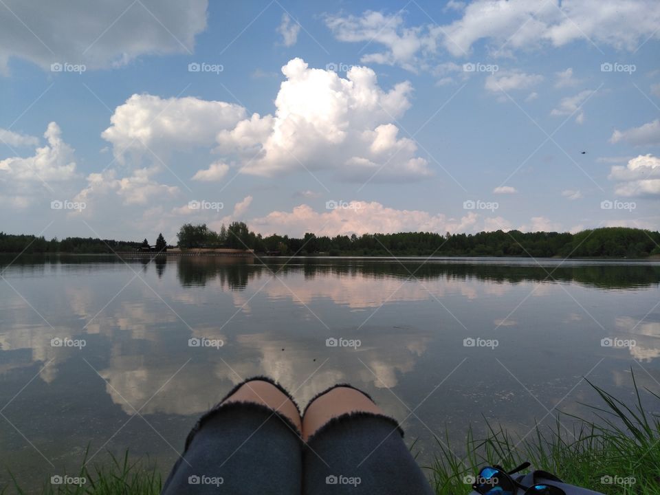 female legs resting on a lake summer landscape