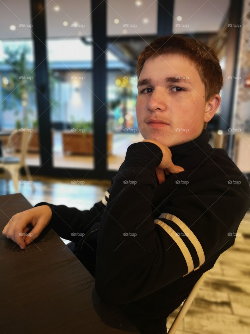 Teenage boy posing for camera at restaurant