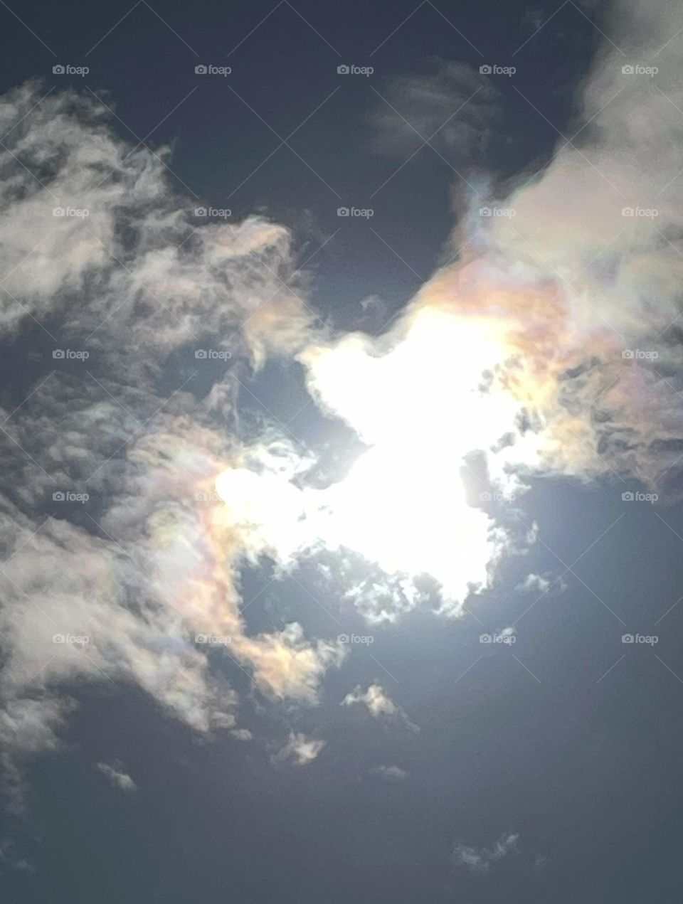 Bizarre sun figure asserting itself between the clouds