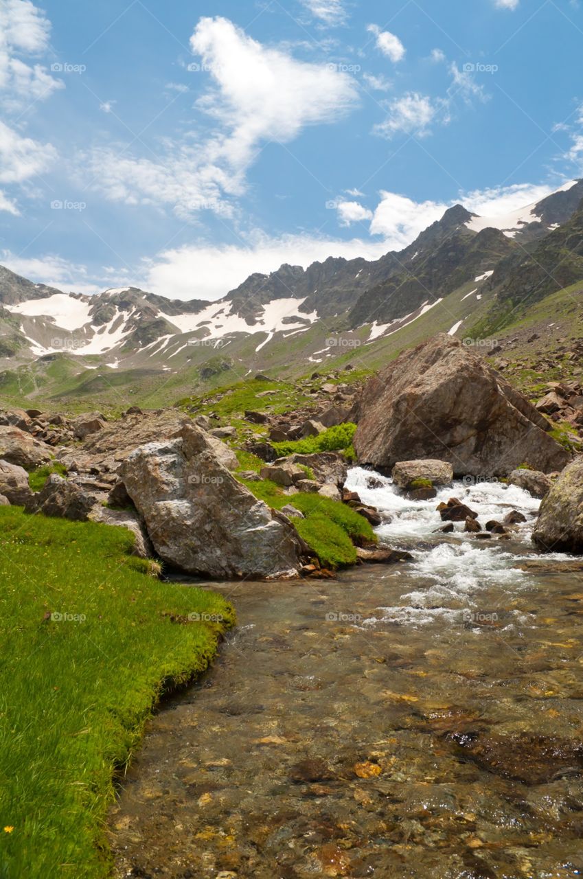 mountain stream with grass on the banks.