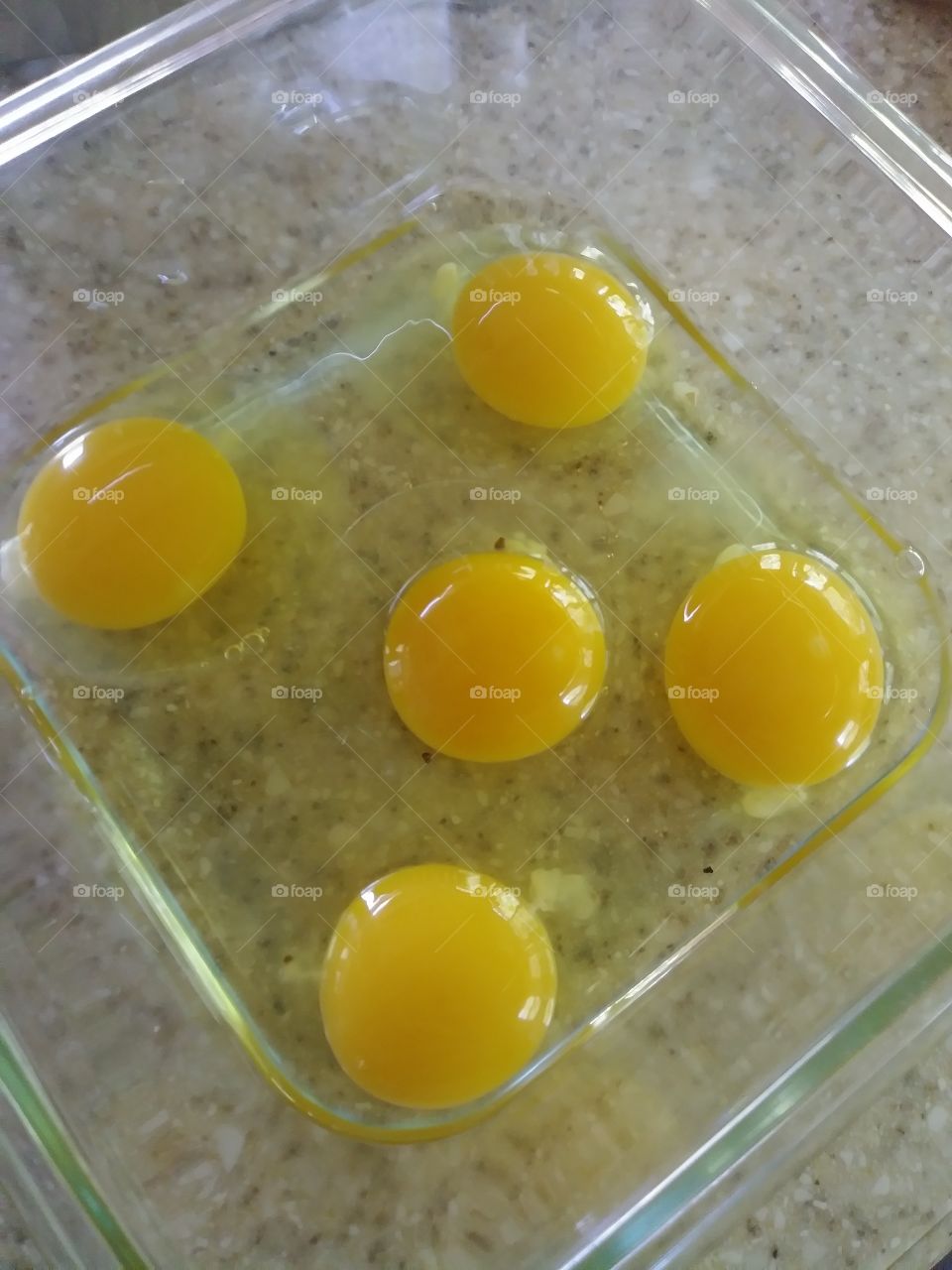 Farm fresh eggs nice whole yellow yokes in borosilcate glass food storage container