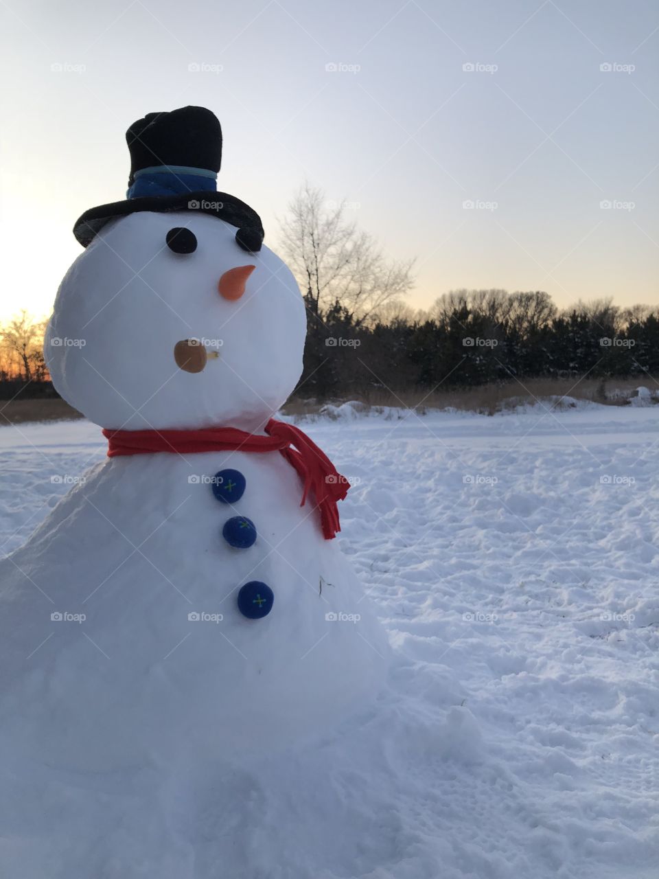 Lumpy snowman and sunset background in Wisconsin 