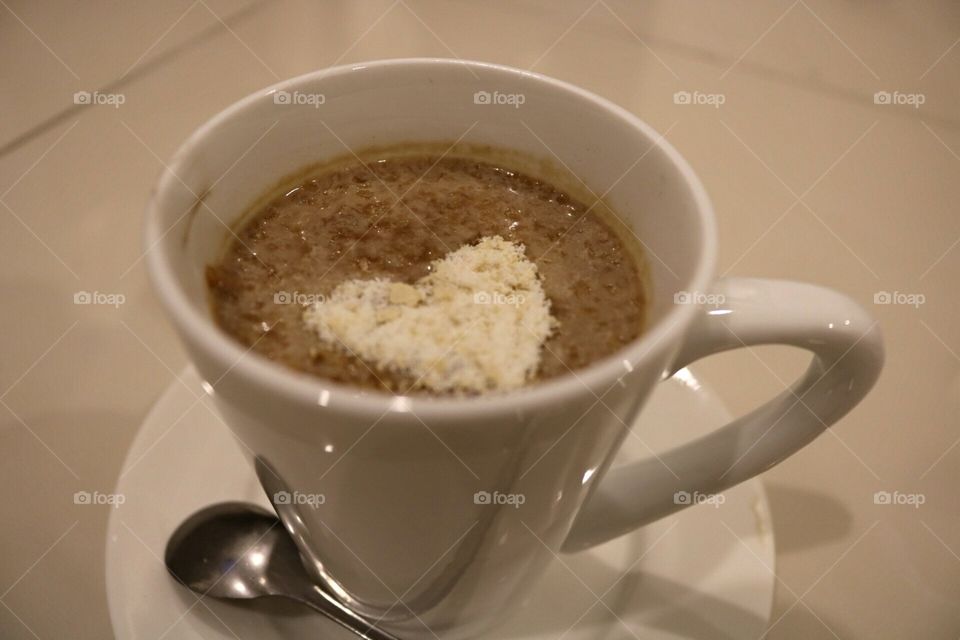 coffee with milk and oatmeal on top shot photo