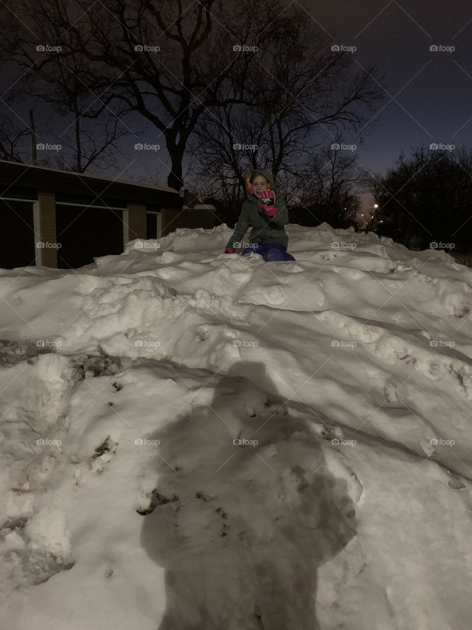 Playing on a snowy hill at night. 