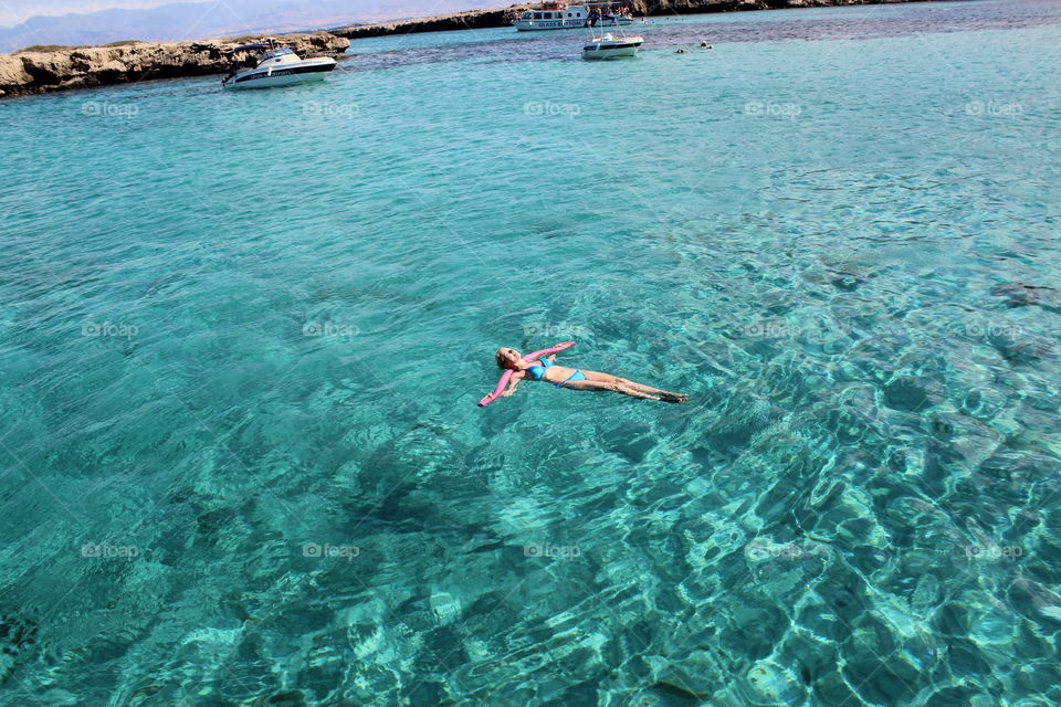 Pretty girl swims in the clear sea