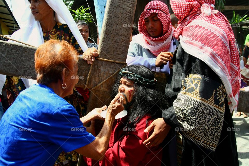a catholic devotee is given food during the reenactment of the death of jesus christ on good friday during holy week in cainta, rizal, philippines, asia