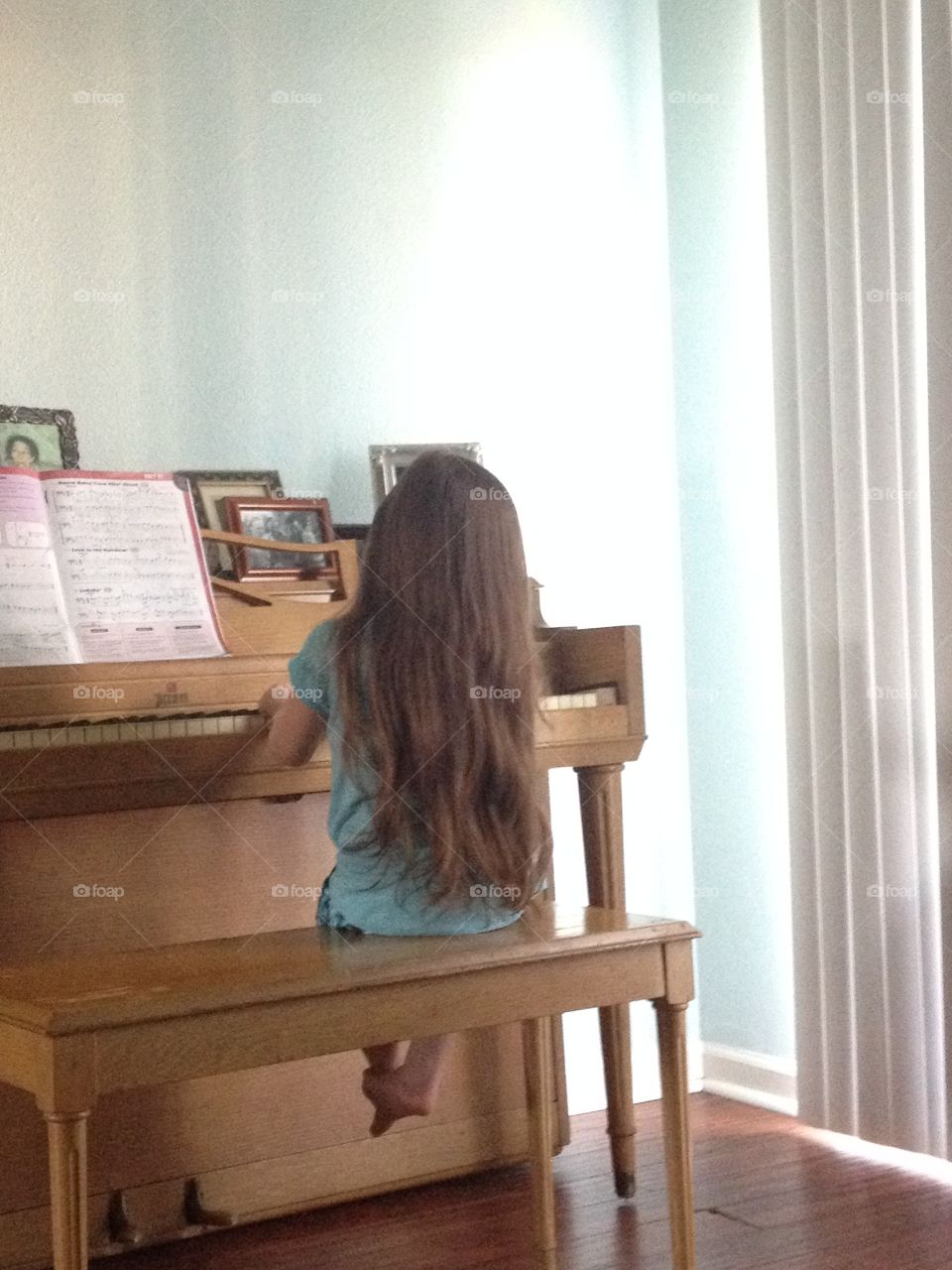 Long hair back of child playing piano
