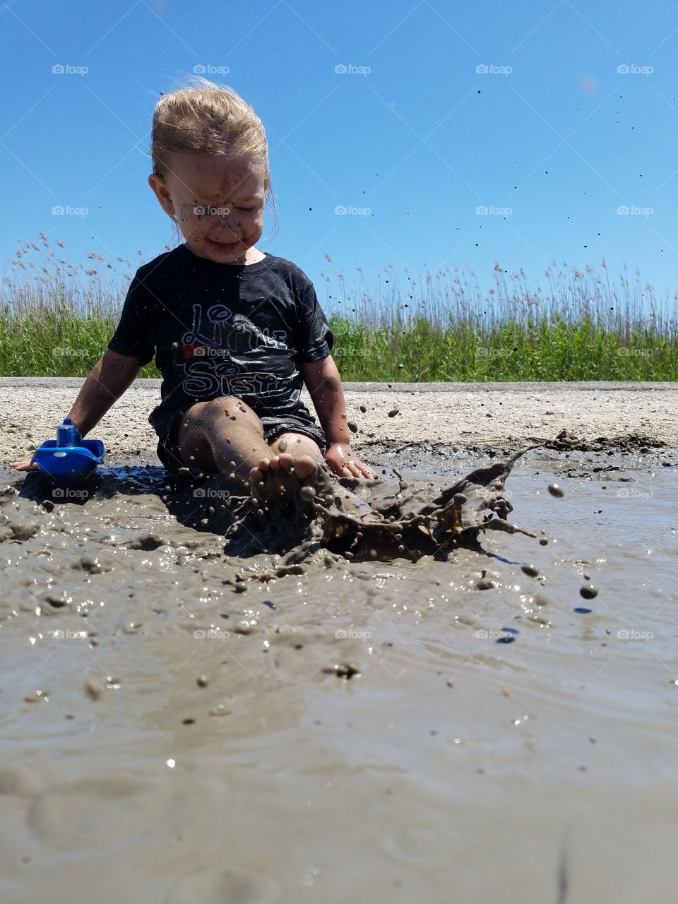 a little girl splashing in the mud just off the Gulf Coast of Texas in Bridge City United States 2018
