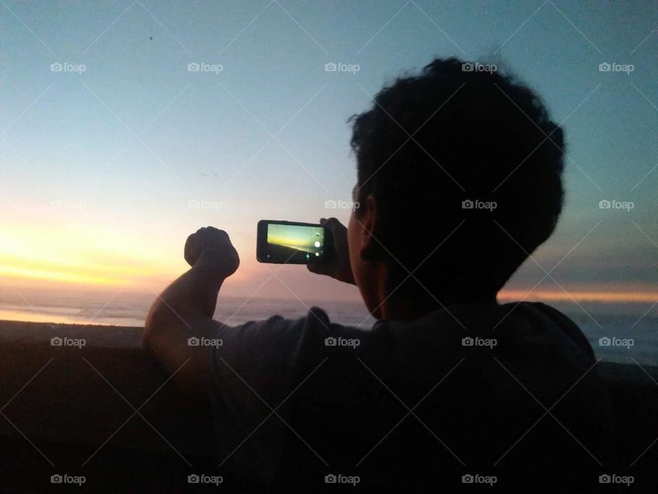 a boy catches videos by using its smartphone .